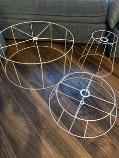 two metal tables sitting on top of a wooden floor next to a gray couch and coffee table