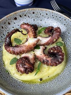 an octopus dish is served in a bowl