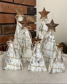 three wooden christmas trees with brown stars on top, tied in twine and placed next to each other