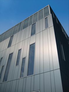 a tall building with many windows on it's side and a blue sky in the background