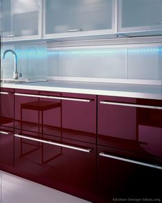 a kitchen with red cabinets and white counter tops