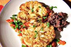 some food is on a white plate with red sauce and parsley sprinkled