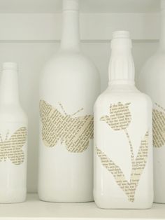 several white vases sitting on top of a shelf with butterflies painted on the bottles