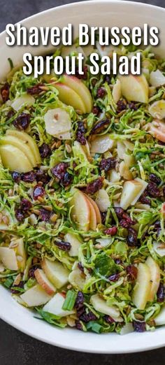 shaved brussels sprouts salad with apples and raisins in a white bowl