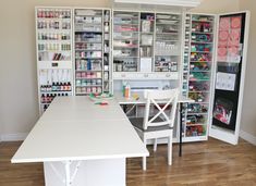 a white table and chairs in a room with lots of shelves on the wall behind it