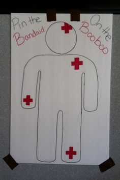 a paper cut out of a man with red crosses on his chest and the words pin the board above him