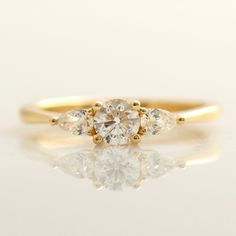 a three stone diamond ring on a white surface