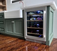 a toy kitchen with green cabinets and white counter tops is shown in this image, it appears to be made out of wood