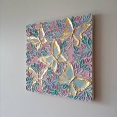 a painting on the wall with gold butterflies and leaves in pastel colors, against a white background