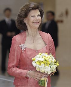 a woman in a red dress holding a bouquet of flowers