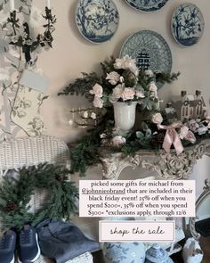 blue and white plates are on the wall next to a vase with flowers in it