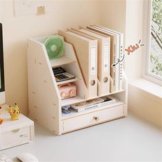 a desk with a computer, books and other items on it