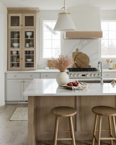 a kitchen with two stools and an island in front of the stove top oven