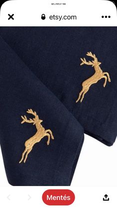 a pair of navy blue towels with gold deer embroidered on them