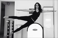 a woman is doing an aerial acrobatic trick on a skateboard in a black and white photo