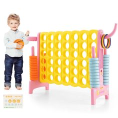 a little boy standing next to a toy basketball game