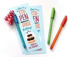 two pens are next to a birthday card