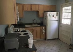 a kitchen with a refrigerator, stove and sink inside of it on tile flooring