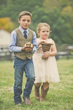 two young children dressed in formal wear holding baskets