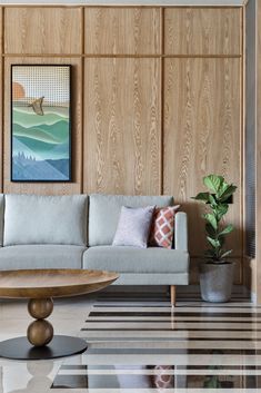 a modern living room with wood paneling and white couches, potted plants