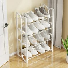 there is a rack with many pairs of shoes on it next to a potted plant