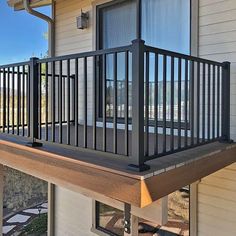 a balcony with metal railings on the side of a house in front of a window