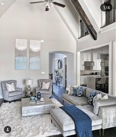 a living room filled with lots of furniture and a ceiling fan in the middle of it