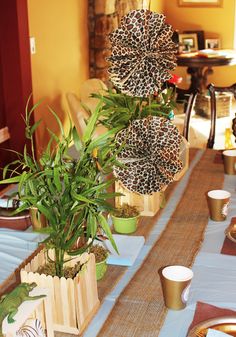 the table is set with plates, cups and vases for dinner guests to enjoy