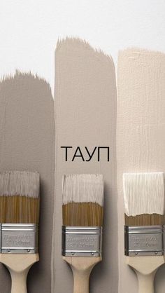 three paint brushes with different shades of white and beige on them, one is brown