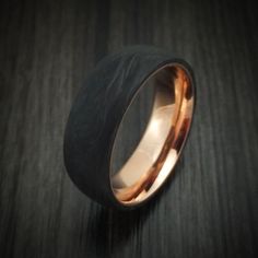 a gold ring with black wood in it