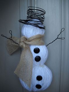 a snowman is hanging on the door with some wire wrapped around it's head