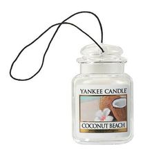 a yankee candle with a cord hanging from it's end and an image of a coconut