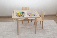 a child's wooden table with two trays and chairs on top of it