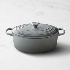 a pot with a lid sitting on top of a white countertop next to a marble surface