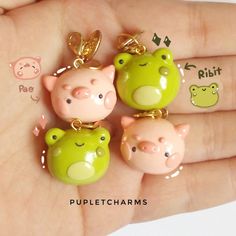 three little pigs are sitting in the palm of someone's hand, with charms attached to them