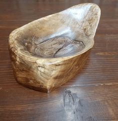 a wooden bowl sitting on top of a wooden table