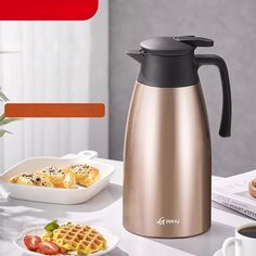 an image of a coffee pot with waffles and fruit on the table next to it