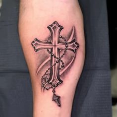 a black and white cross tattoo on the leg