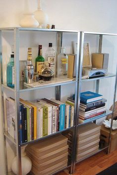 a book shelf filled with lots of books on top of a hard wood floor