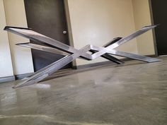 a metal sculpture sitting on top of a cement floor