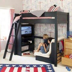 a young boy sitting on top of a bunk bed next to a flag rug in a bedroom