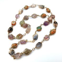 *Description: This is a beautiful gemstone wire wrapped vintage necklace from the 1960s to 1970s.  I tested the stones with the Presidium Gem Tester and each stone tested as a gemstone. Some of the stones include amethyst, jade, agate, and carnelian. The gold plated wire is wrapped around each gemstone in a very artistic manner. This would be a great necklace for your collection to wear for years to come. This would be a great addition to your vintage jewelry collection or make a great vintage gift! *Approximate Measurements: Length - 30 Inches, Weight - 2.2 Ounces *Condition: Very good vintage condition.  Will see signs of wear under magnification. See photos for details. *Hallmark:  Unsigned *Item # 6031 Please look at the photos carefully as they are a part of the description. We are mo Vintage Gemstone Necklace For Healing, Vintage Healing Gemstone Necklace, Vintage Crystal Necklaces For Jewelry Making With Natural Stones, Vintage Multicolor Gemstone Beads And Cabochons, Vintage Crystal Necklaces For Jewelry Making, Vintage Wire Wrapped Necklace For Healing, Vintage Multicolor Wire Wrapped Jewelry, Vintage Natural Gemstones, Vintage Multicolor Agate Jewelry