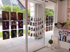 a room with many pictures on the wall and photos pinned to the glass doors,