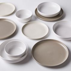 several white and beige plates are arranged on a table