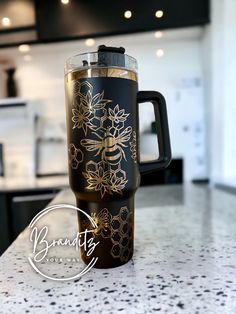 a black and gold coffee cup sitting on top of a kitchen counter next to an oven