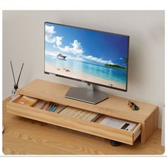 a flat screen tv sitting on top of a wooden table next to a book shelf