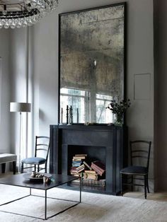 a living room filled with furniture and a large mirror on the wall over a fire place