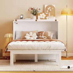 a white bed sitting in a bedroom on top of a hard wood floor next to a lamp