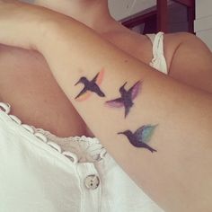 a woman's arm with three birds on it