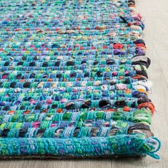 a multicolored rug is laying on the floor with it's fringed edges